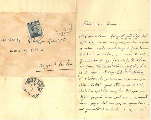 Foglio bianco piegato a metà con parte della busta viaggiata