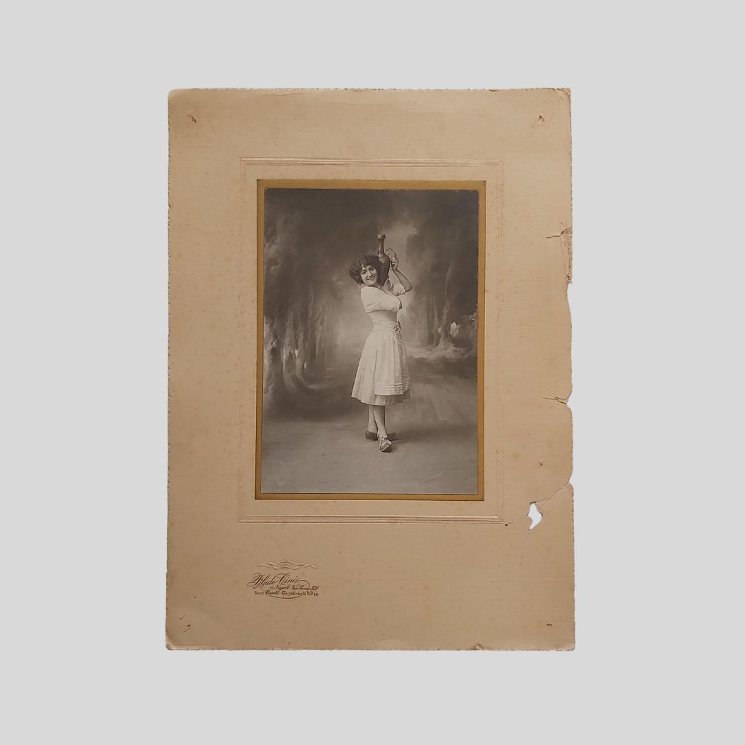 Ritratto fotografico in abiti di scena con anfora sulla spalla.