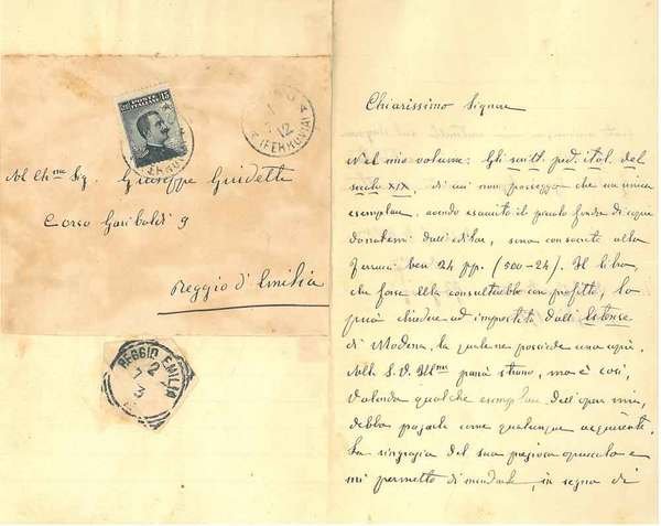 Foglio bianco piegato a metà con parte della busta viaggiata