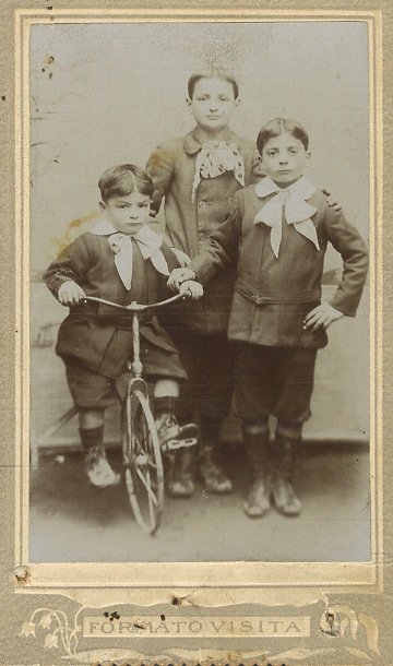 Ritratto fotografico di tre bambini (uno su una bicicletta o …