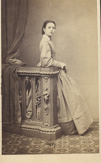 Ritratto fotografico di una giovane donna in piedi, che si …
