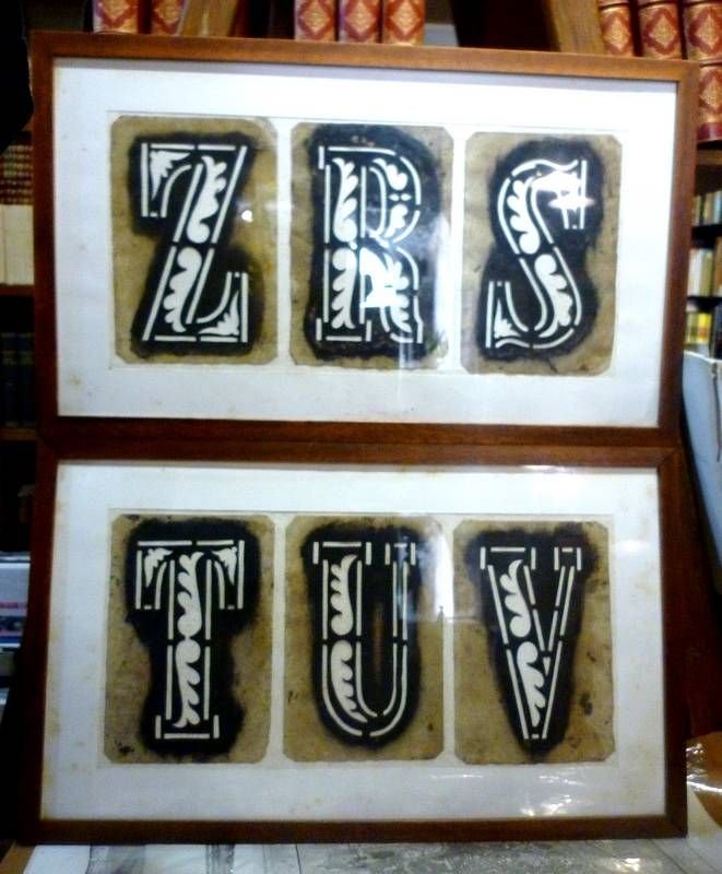 Diciannove cartoncini perforati per dipingere scritte per insegne o cartelloni.