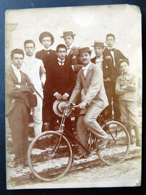 Gruppo di giovani uomini e una bicicletta.