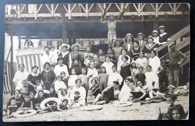 Gruppo di villeggianti con bagnino e salvagenti in spiaggia (Bagni …